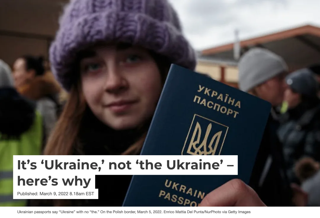 网页截图，标题为'It's 'Ukraine,' not 'the Ukraine' – here's why'，配图是一名戴毛线帽的年轻女性在边境展示乌克兰护照，封面印有'УКРАЇНА ПАСПОРТ'字样和国徽。