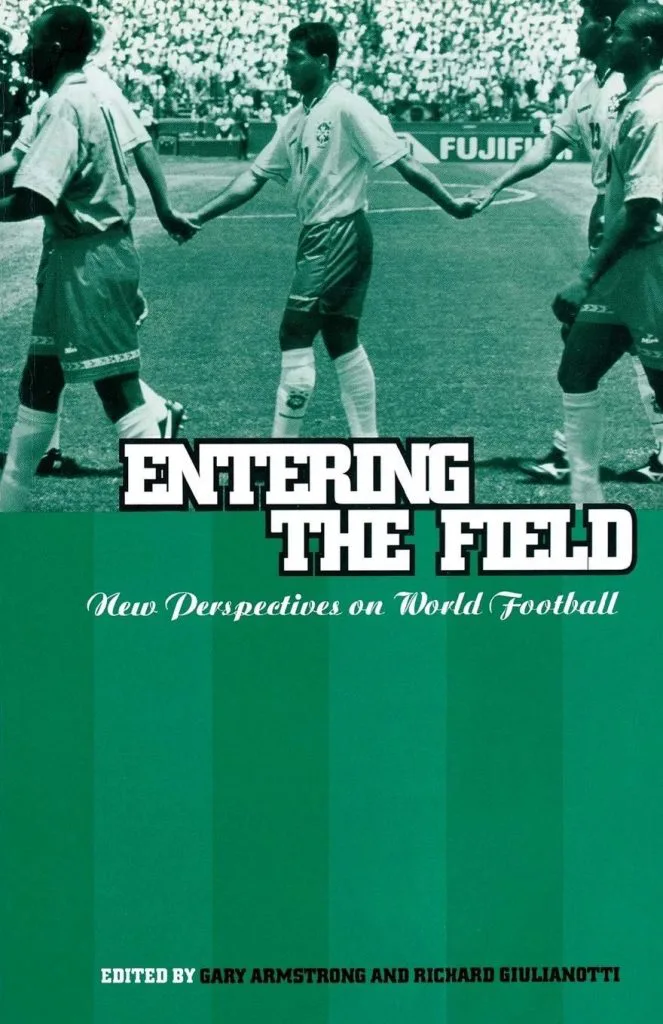 书封《Entering the Field: New Perspectives on World Football》，编者Gary Armstrong和Richard Giulianotti，上部为球员牵手入场的黑白球场照片，下部绿色球场纹底